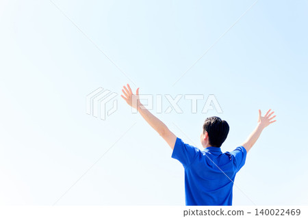 一位亞裔男性護理員舉起雙手指向藍天。 140022469