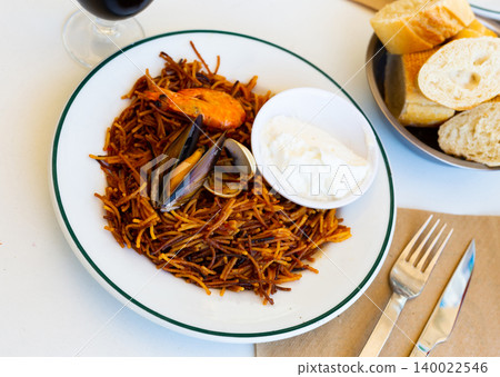 Fideua, noodle paella with seafoods and alioli Fideua, noodle paella with seafoods and alioli 140022546