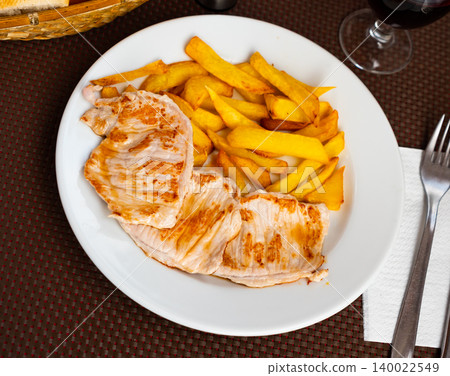 Juicy roasted loin chops served with french fries and wine closeup Juicy roasted loin chops served with french fries and wine closeup 140022549