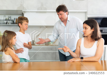 Angry parents scolding two children standing in front of them Angry parents scolding two children standing in front of them 140022553