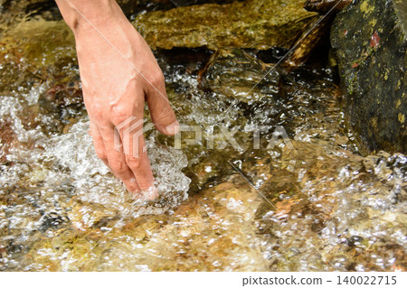 An outdoor scene where you dip your hands in a clear stream and feel the coolness. An outdoor scene where you dip your hands in a clear stream and feel the coolness. 140022715