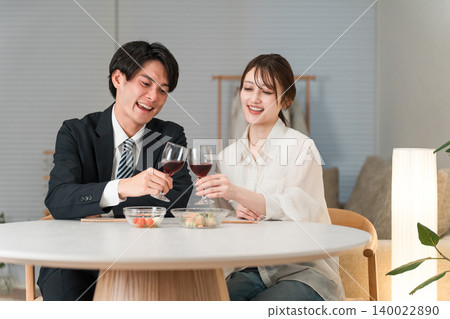 一對夫婦在傍晚的餐桌旁享用葡萄酒,舉杯慶祝。 一對夫婦在傍晚的餐桌旁享用葡萄酒,舉杯慶祝。 140022890