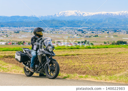 從戀人坂(Koibitozaka)眺望白雪皚皚的飯出山和一輛摩托車。 從戀人坂(Koibitozaka)眺望白雪皚皚的飯出山和一輛摩托車。 140022983
