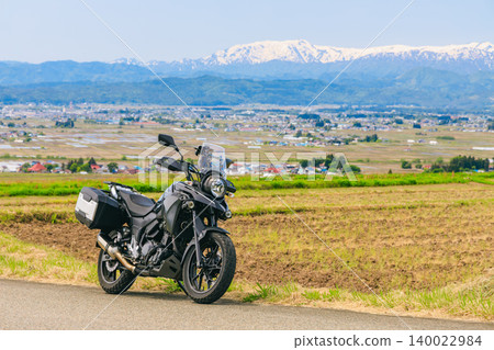 A view of snow-capped Mt. Iide and a motorcycle from Koibitozaka (Lover's Hill). A view of snow-capped Mt. Iide and a motorcycle from Koibitozaka (Lover's Hill). 140022984