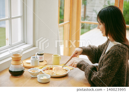 A woman living alone enjoys making her own breakfast. A woman living alone enjoys making her own breakfast. 140023995