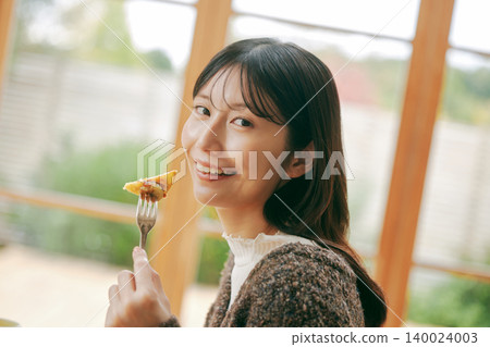 A woman living alone enjoys making her own breakfast. A woman living alone enjoys making her own breakfast. 140024003