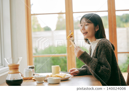 A woman living alone enjoys making her own breakfast. A woman living alone enjoys making her own breakfast. 140024006