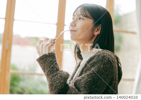 A woman living alone enjoys making her own breakfast. A woman living alone enjoys making her own breakfast. 140024010