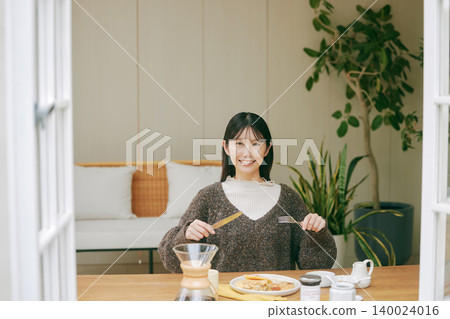 A woman living alone enjoys making her own breakfast. A woman living alone enjoys making her own breakfast. 140024016