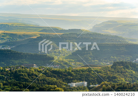Layers of green mountains and hills in the haze during sunset. Panoramic View of Green hills and Meadow. Layers of green mountains and hills in the haze during sunset. Panoramic View of Green hills and Meadow. 140024210