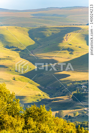 Layers of green mountains and hills in the haze during sunset. Panoramic View of Green hills and Meadow. Layers of green mountains and hills in the haze during sunset. Panoramic View of Green hills and Meadow. 140024213
