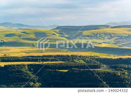 Layers of green mountains and hills in the haze during sunset. Panoramic View of Green hills and Meadow. Layers of green mountains and hills in the haze during sunset. Panoramic View of Green hills and Meadow. 140024332