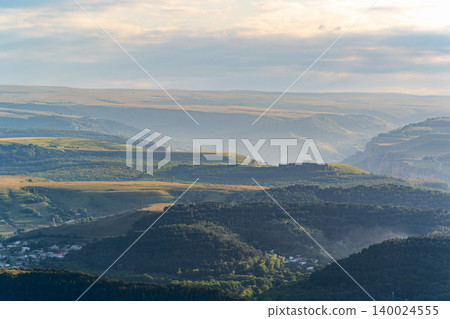 Layers of green mountains and hills in the haze during sunset. Panoramic View of Green hills and Meadow. Layers of green mountains and hills in the haze during sunset. Panoramic View of Green hills and Meadow. 140024555