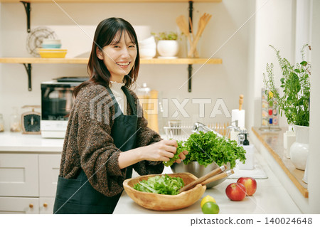 一位女士正在用新鮮蔬菜做飯 140024648