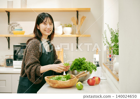 A woman cooking with fresh vegetables A woman cooking with fresh vegetables 140024650