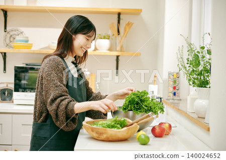 A woman cooking with fresh vegetables 140024652