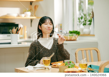 一位女士正在津津有味地用餐。 一位女士正在津津有味地用餐。 140024966