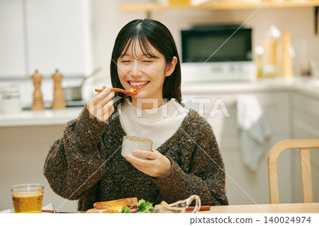 一位女士正在津津有味地用餐。 一位女士正在津津有味地用餐。 140024974