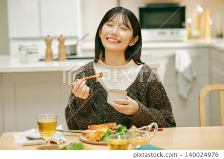 一位女士正在津津有味地用餐。 一位女士正在津津有味地用餐。 140024976