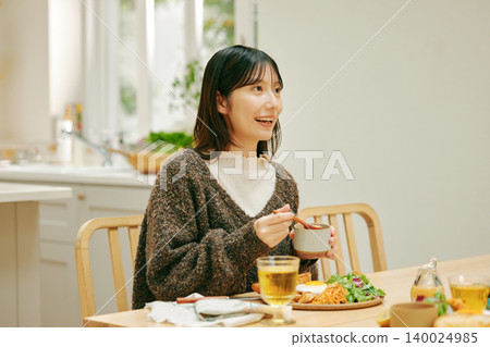 一位女士正在津津有味地用餐。 一位女士正在津津有味地用餐。 140024985