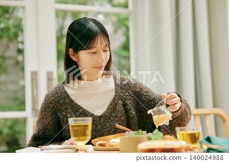 一位女士正在津津有味地用餐。 一位女士正在津津有味地用餐。 140024988