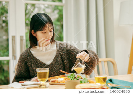A woman eating her meal with apparent enjoyment. A woman eating her meal with apparent enjoyment. 140024990