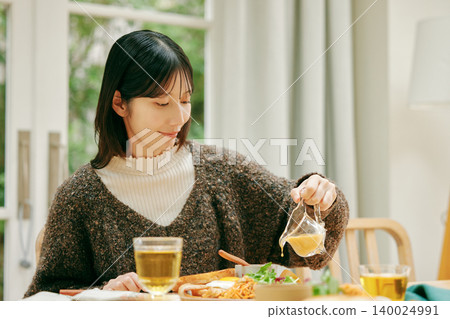 A woman eating her meal with apparent enjoyment. A woman eating her meal with apparent enjoyment. 140024991