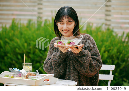 A woman eating tacos in her garden 140025049