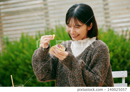 一位女士在花園裡吃墨西哥捲餅 140025057