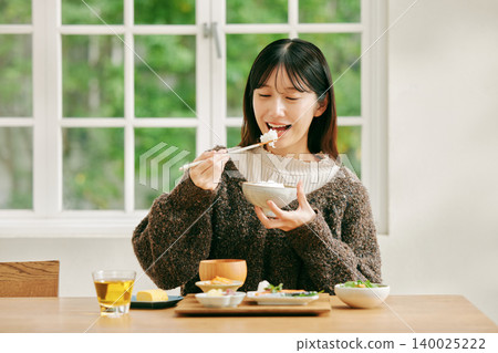 一位女士正在享用日式早餐。 140025222