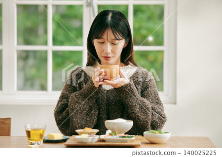 一位女士正在享用日式早餐。 140025225
