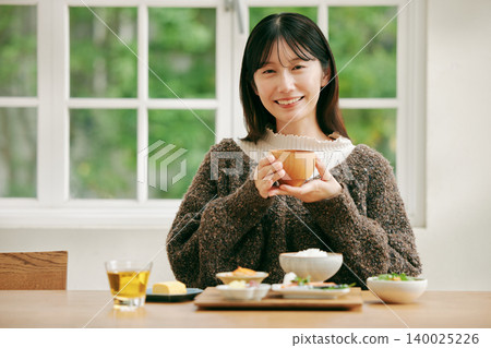 一位女士正在享用日式早餐。 140025226
