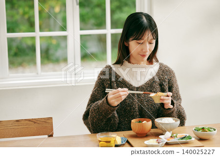 一位女士正在享用日式早餐。 140025227