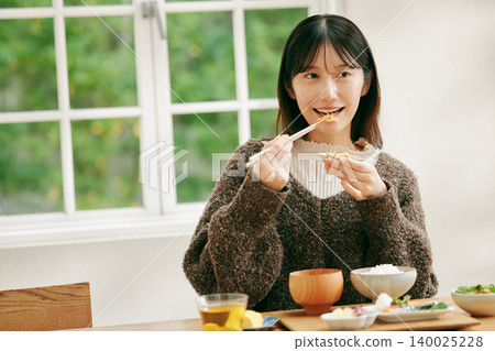 一位女士正在享用日式早餐。 140025228