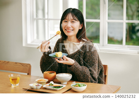 A woman eating a Japanese-style breakfast. A woman eating a Japanese-style breakfast. 140025232