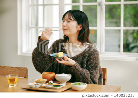 A woman eating a Japanese-style breakfast. A woman eating a Japanese-style breakfast. 140025233