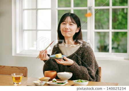 一位女士正在享用日式早餐。 140025234