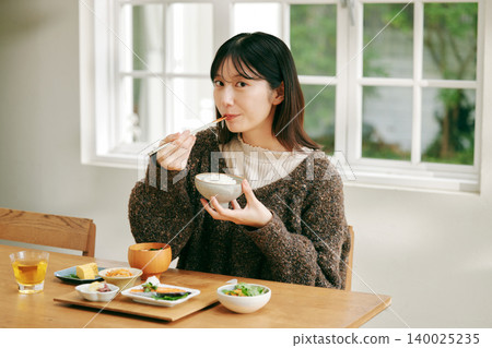 一位女士正在享用日式早餐。 140025235