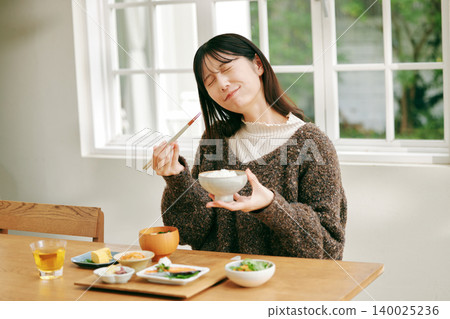一位女士正在享用日式早餐。 140025236