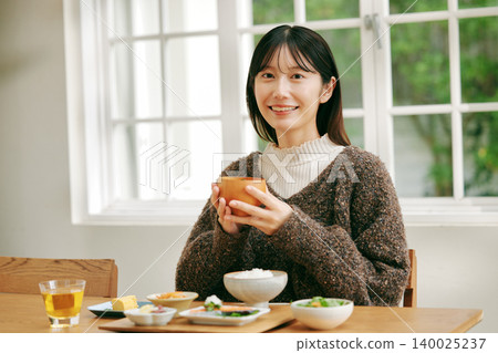 一位女士正在享用日式早餐。 一位女士正在享用日式早餐。 140025237