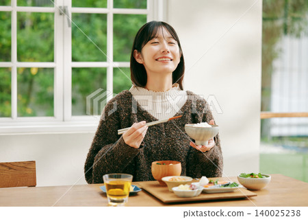 一位女士正在享用日式早餐。 140025238