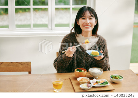 一位女士正在享用日式早餐。 140025242