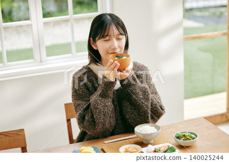 一位女士正在享用日式早餐。 一位女士正在享用日式早餐。 140025244