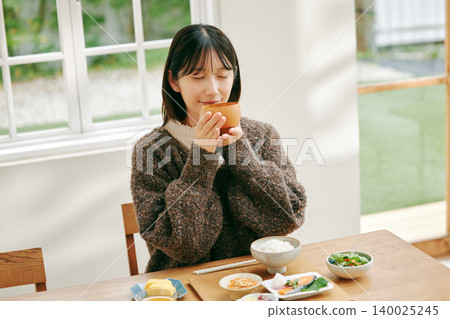 一位女士正在享用日式早餐。 一位女士正在享用日式早餐。 140025245