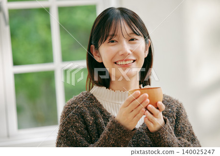 一位女士正在享用日式早餐。 140025247