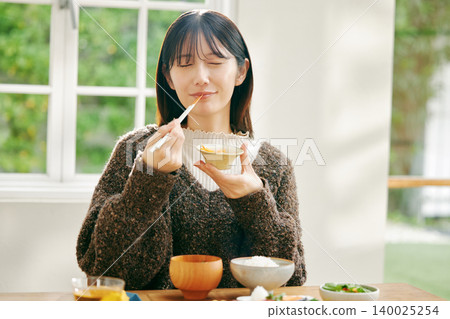 一位女士正在享用日式早餐。 140025254