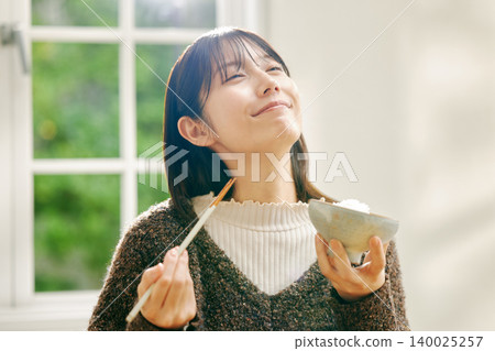 一位女士正在享用日式早餐。 140025257