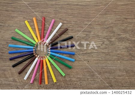 Colored pencils lined up on a wooden table Colored pencils lined up on a wooden table 140025432