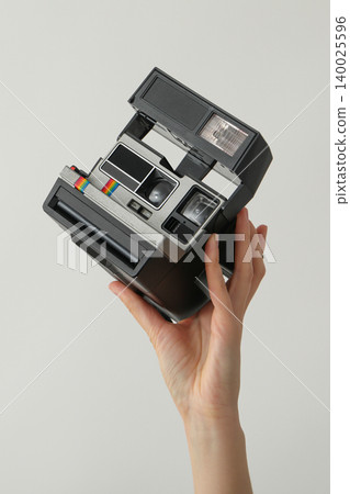 A hand holds a vintage camera ready to take a picture 140025596