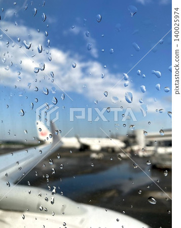 Fresh raindrops clinging to the airplane window at the airport after the rain. Fresh raindrops clinging to the airplane window at the airport after the rain. 140025974